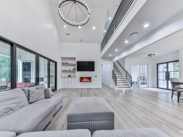 106 Belmont Dr, Canton, GA 30115 - living room with a high ceiling, light wood-type flooring, recessed lighting, french doors, and a lit fireplace