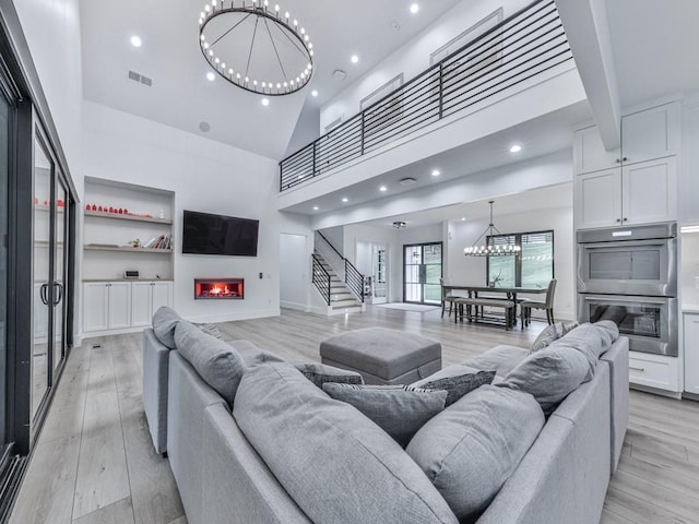 106 Belmont Dr, Canton, GA 30115 - living area featuring a chandelier, a glass covered fireplace, stairs, light wood finished floors, and recessed lighting