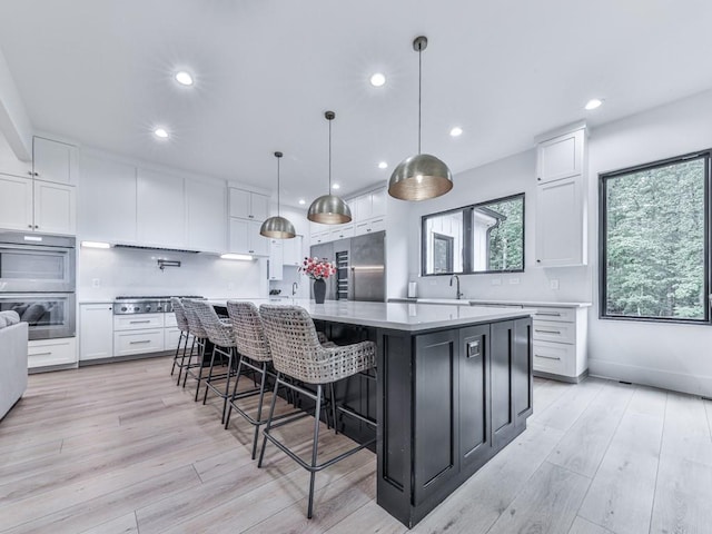 106 Belmont Dr, Canton, GA 30115 - kitchen featuring stainless steel appliances, white cabinets, light wood-style floors, decorative backsplash, and recessed lighting