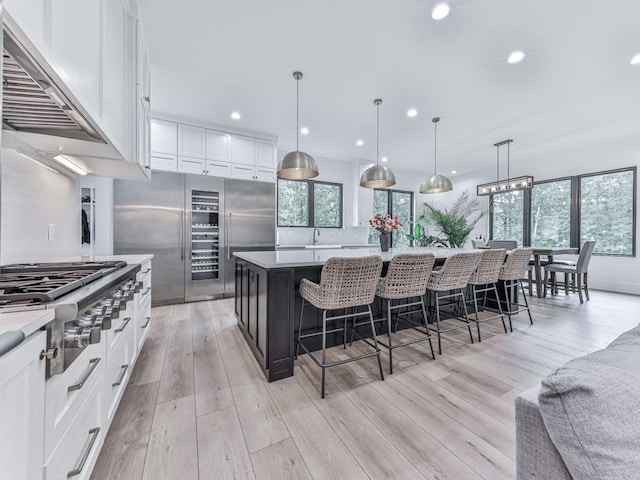 106 Belmont Dr, Canton, GA 30115 - kitchen with stainless steel gas cooktop, fridge, light wood-type flooring, white cabinets, and light countertops