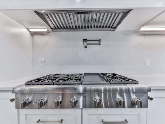 106 Belmont Dr, Canton, GA 30115 - kitchen view of exhaust hood, stainless steel gas cooktop, white cabinetry, and light countertops