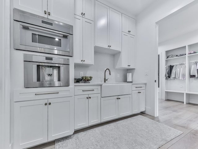 106 Belmont Dr, Canton, GA 30115 - kitchen featuring light wood-style flooring, light countertops, oven, and white cabinetry