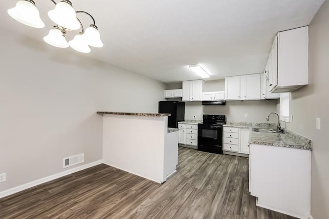 kitchen featuring extractor fan, pendant lighting, white cabinetry, sink, and black appliances