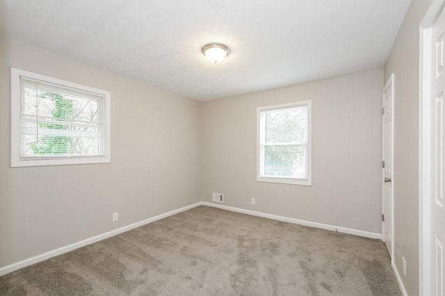 spare room featuring light colored carpet