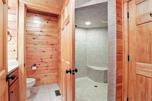 929 Hickory Nut Mountain Rd, Tallulah Falls, GA 30573 - bathroom featuring a tile shower, tile patterned flooring, wood walls, and recessed lighting