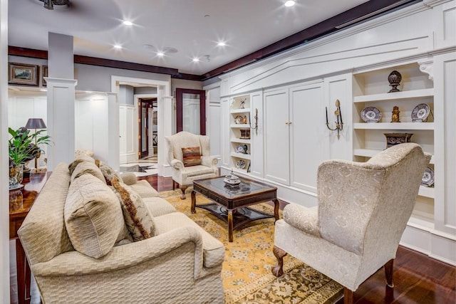 interior space with a decorative wall, built in shelves, recessed lighting, wood finished floors, and ornate columns