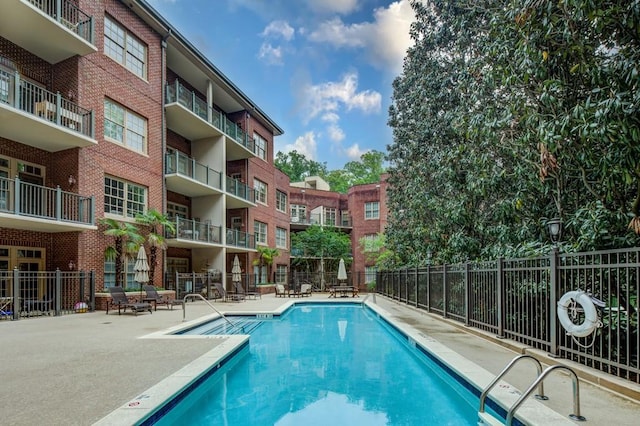 pool with a patio and fence