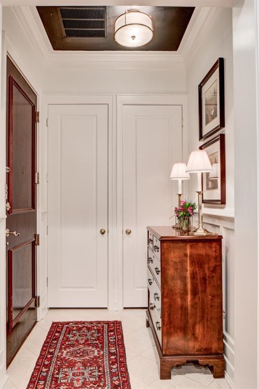 interior space with crown molding and light tile patterned floors