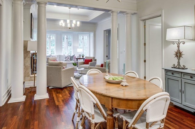 dining room featuring ornate columns, ornamental molding, dark wood-style flooring, and a tray ceiling