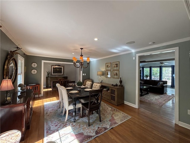 dining space featuring a chandelier, ornamental molding, dark wood-type flooring, and baseboards