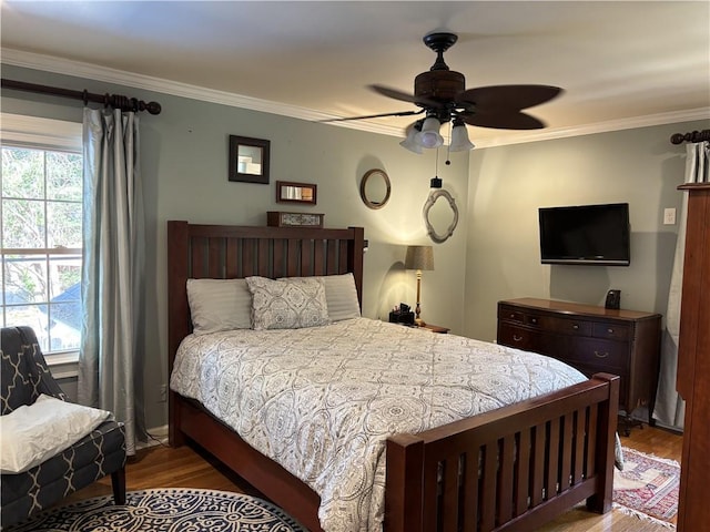 bedroom with wood finished floors, crown molding, and a ceiling fan