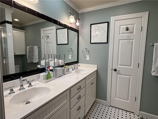 full bath featuring crown molding, double vanity, baseboards, and toilet