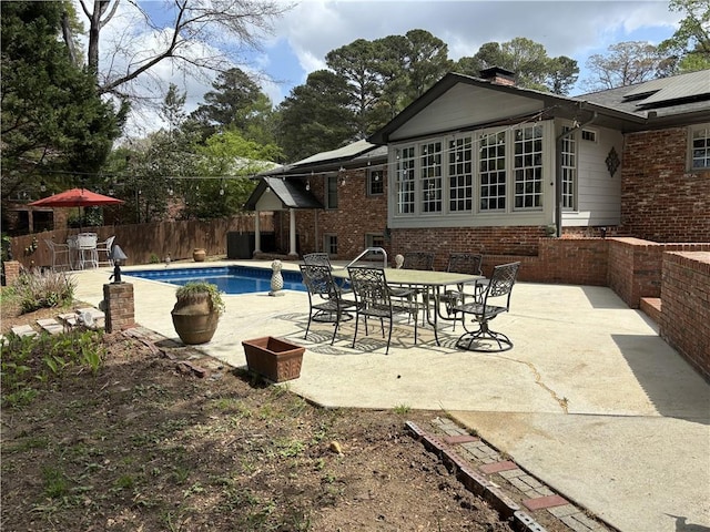 view of pool with a patio area, outdoor dining space, and a fenced backyard