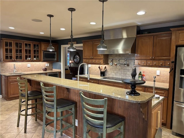 kitchen featuring wall chimney exhaust hood, a sink, appliances with stainless steel finishes, decorative backsplash, and crown molding