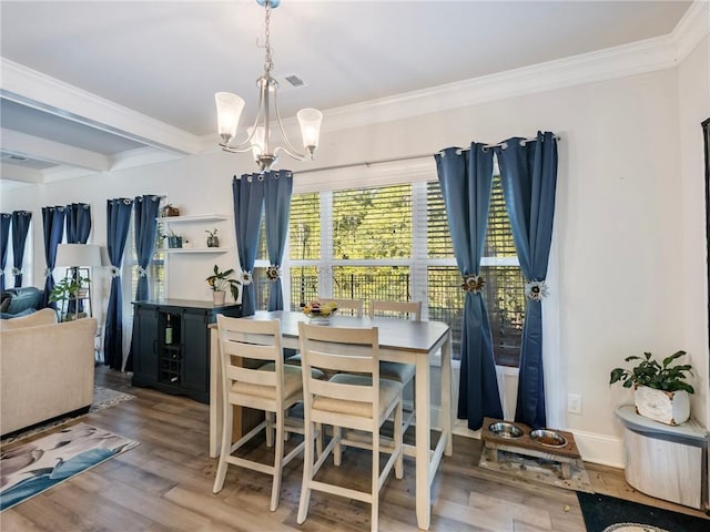 dining room with ornamental molding, hardwood / wood-style floors, and a chandelier