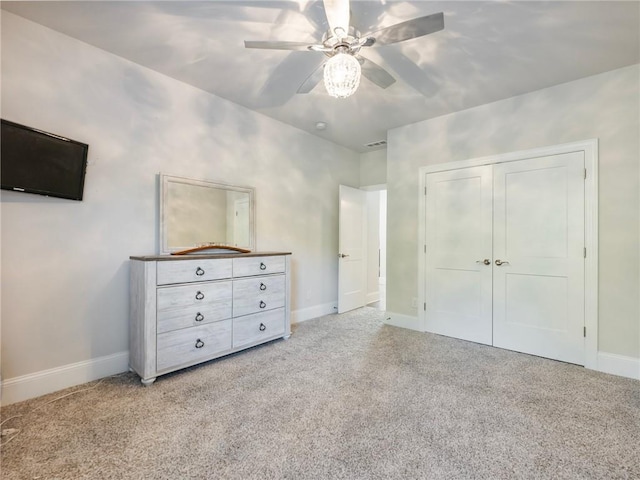 unfurnished bedroom with a closet, carpet floors, and ceiling fan