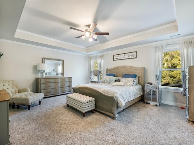 carpeted bedroom featuring ceiling fan, ornamental molding, and a tray ceiling