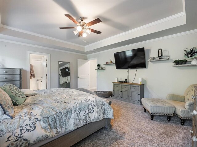 carpeted bedroom with crown molding, a tray ceiling, and ceiling fan