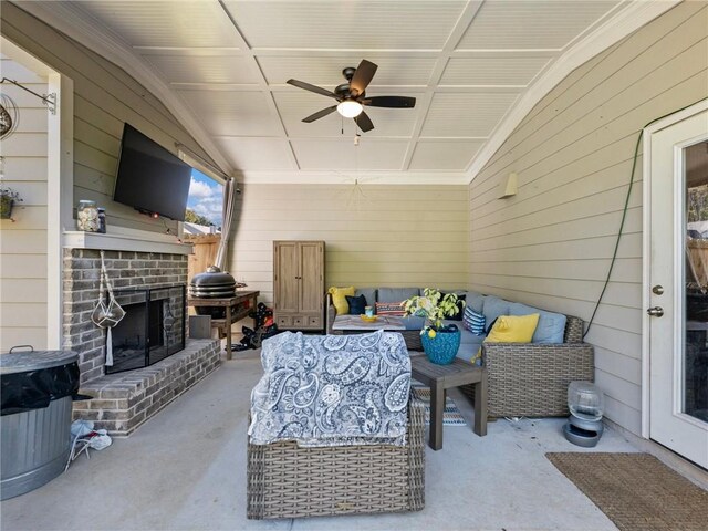 view of patio / terrace with ceiling fan and an outdoor living space with a fireplace