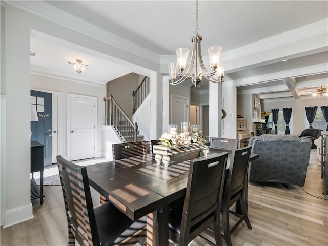 dining space featuring light hardwood / wood-style floors, crown molding, beamed ceiling, and ceiling fan