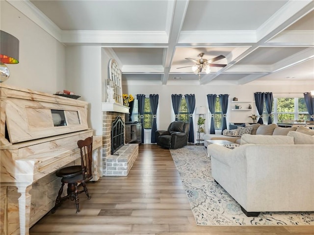 living room with coffered ceiling, wood-type flooring, beamed ceiling, and a brick fireplace