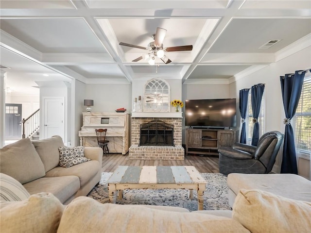 living room featuring coffered ceiling, a fireplace, wood-type flooring, and ceiling fan