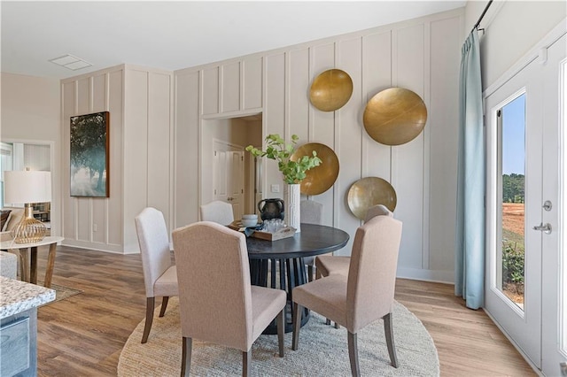 dining room with french doors and light hardwood / wood-style floors