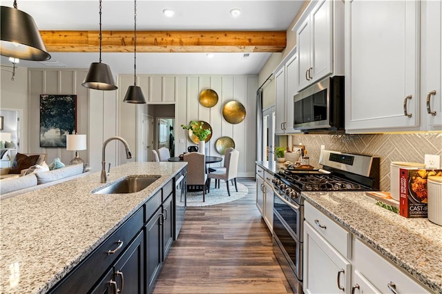 kitchen with sink, decorative light fixtures, appliances with stainless steel finishes, beamed ceiling, and white cabinets