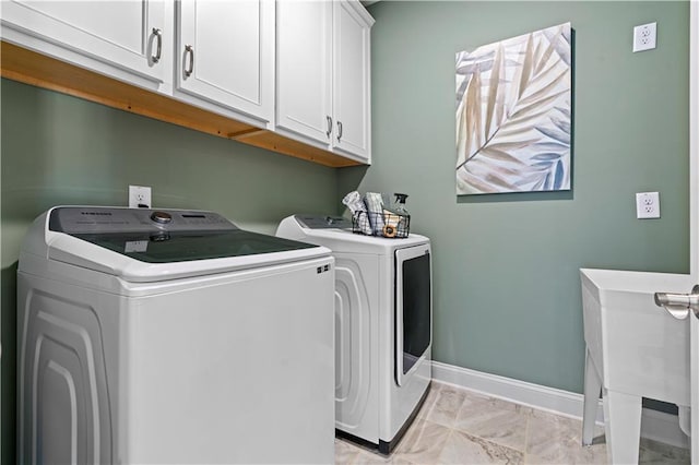 washroom featuring cabinets, sink, and washer and dryer