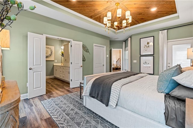 bedroom with hardwood / wood-style floors, a chandelier, a tray ceiling, wooden ceiling, and ensuite bath