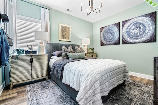 bedroom featuring hardwood / wood-style flooring and a notable chandelier