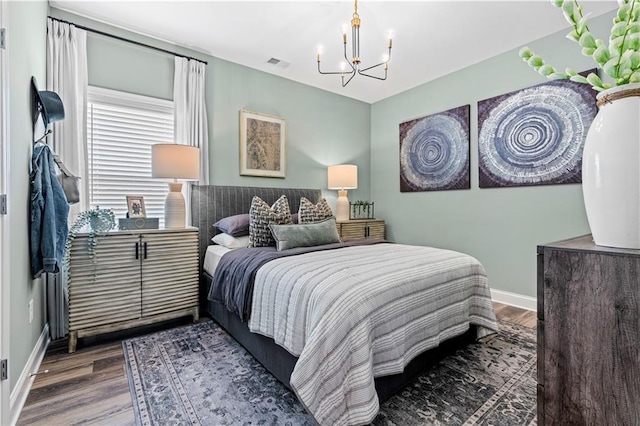 bedroom with hardwood / wood-style floors and a notable chandelier