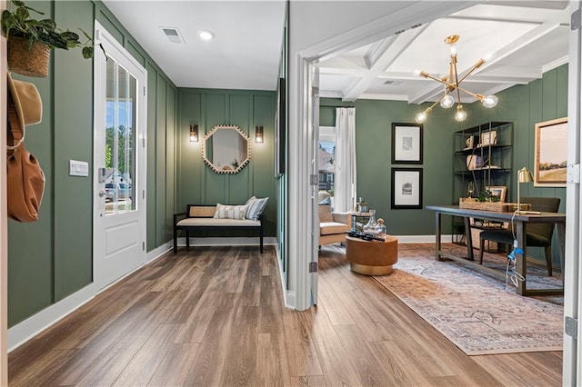 interior space with coffered ceiling, hardwood / wood-style floors, beam ceiling, and a notable chandelier