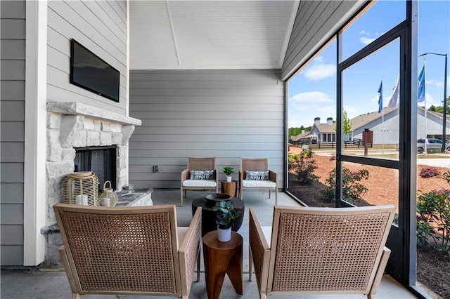 sunroom / solarium featuring an outdoor stone fireplace