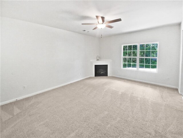 unfurnished living room featuring ceiling fan and light colored carpet