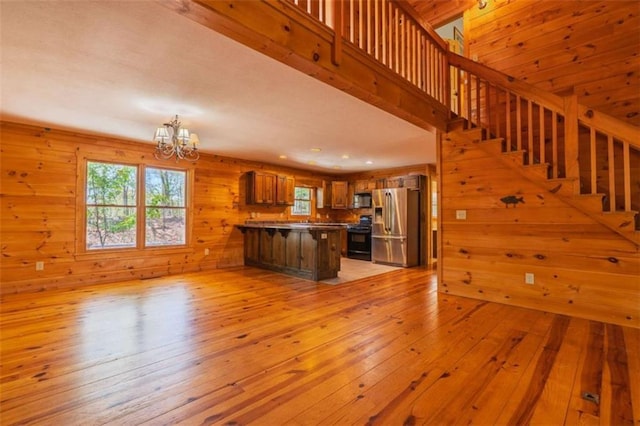 342 Zenith Trl, Ellijay, GA 30540 - interior space with a notable chandelier, open floor plan, a peninsula, light wood finished floors, and black appliances