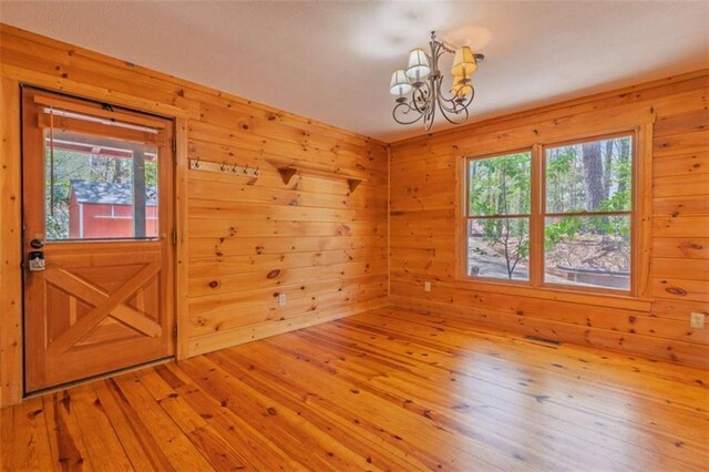 342 Zenith Trl, Ellijay, GA 30540 - spare room featuring wooden walls, hardwood / wood-style floors, a chandelier, and a healthy amount of sunlight