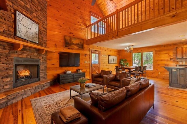 342 Zenith Trl, Ellijay, GA 30540 - living area featuring an inviting chandelier, hardwood / wood-style flooring, a fireplace, wood walls, and high vaulted ceiling