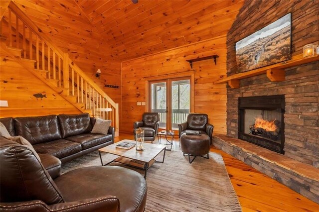 342 Zenith Trl, Ellijay, GA 30540 - living room with a stone fireplace, hardwood / wood-style flooring, stairway, wood walls, and lofted ceiling
