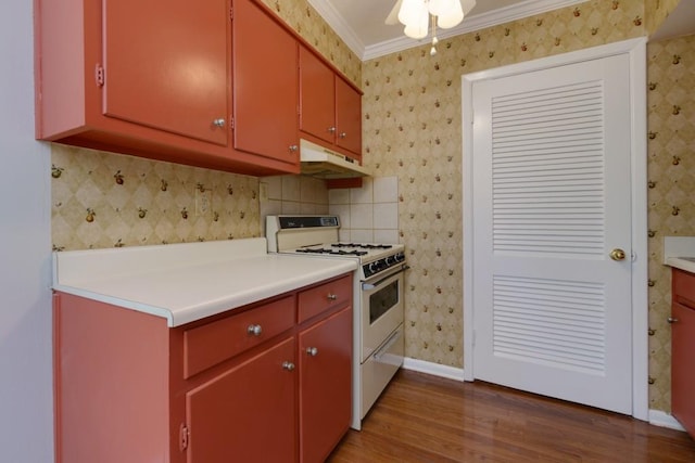 kitchen with wood finished floors, white gas range, under cabinet range hood, crown molding, and red cabinets