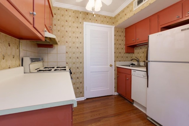 kitchen featuring white appliances, visible vents, a sink, wood finished floors, and light countertops