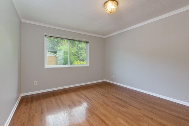 unfurnished room with ornamental molding, baseboards, and hardwood / wood-style floors