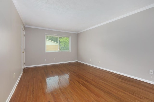 empty room with crown molding, baseboards, and wood-type flooring