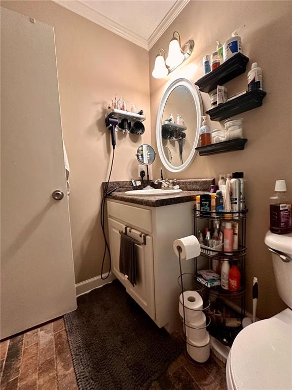 bathroom featuring crown molding, vanity, and toilet