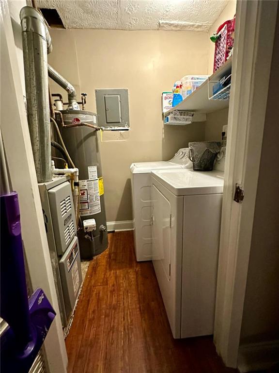 laundry room with dark wood-type flooring, electric panel, separate washer and dryer, a textured ceiling, and water heater