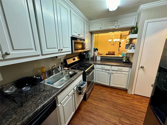 kitchen with white cabinetry, sink, dark wood-type flooring, a chandelier, and appliances with stainless steel finishes