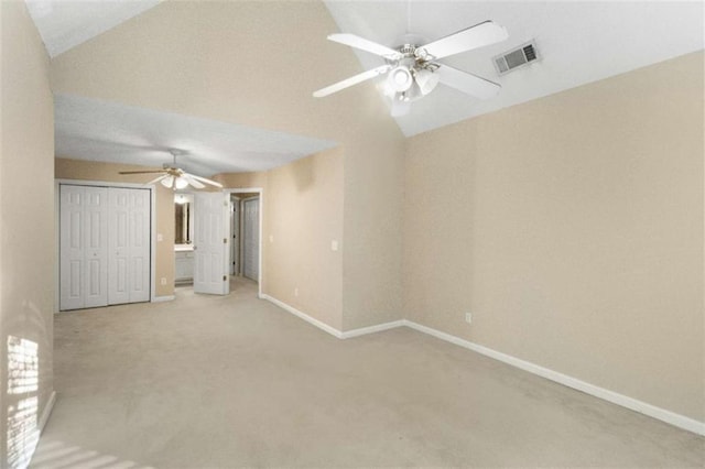 spare room featuring light carpet, ceiling fan, and vaulted ceiling