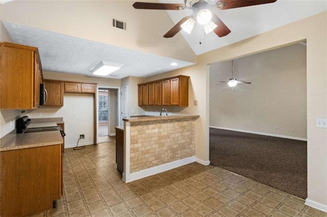 kitchen featuring ceiling fan, stove, kitchen peninsula, and light carpet