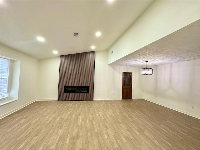 850 Greenhedge Dr, Stone Mountain, GA 30088 - unfurnished living room with light wood-style floors, a large fireplace, recessed lighting, and a chandelier