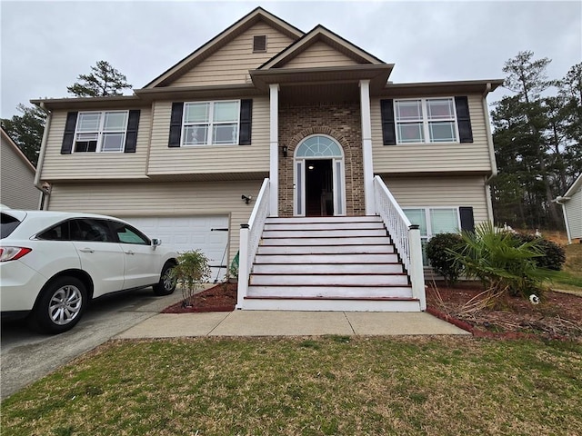 bi-level home featuring a garage, brick siding, and driveway